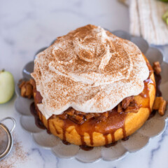 Single layer cake with a whipped topping on a scalloped plate.