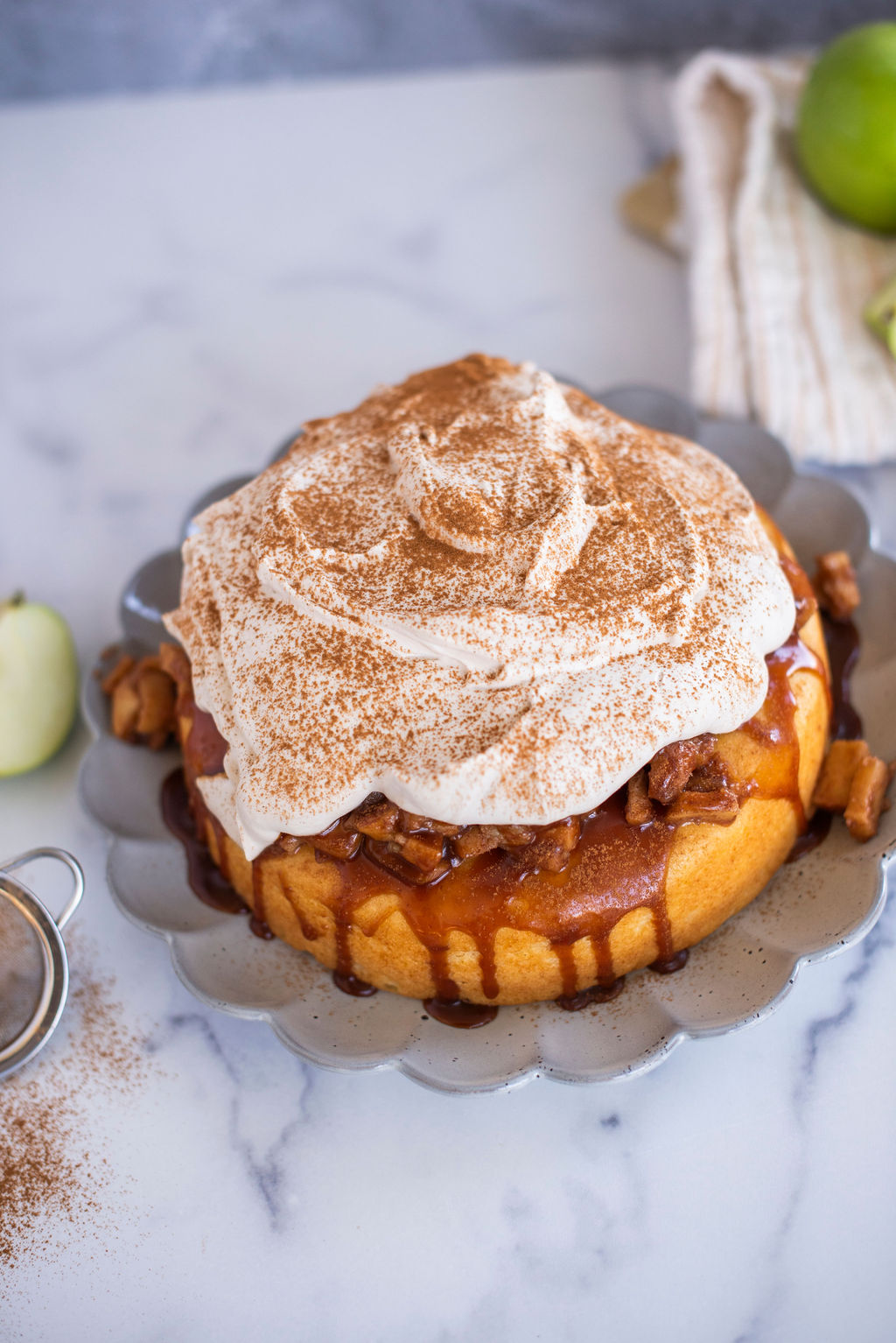 Single layer cake with a whipped topping on a scalloped plate.