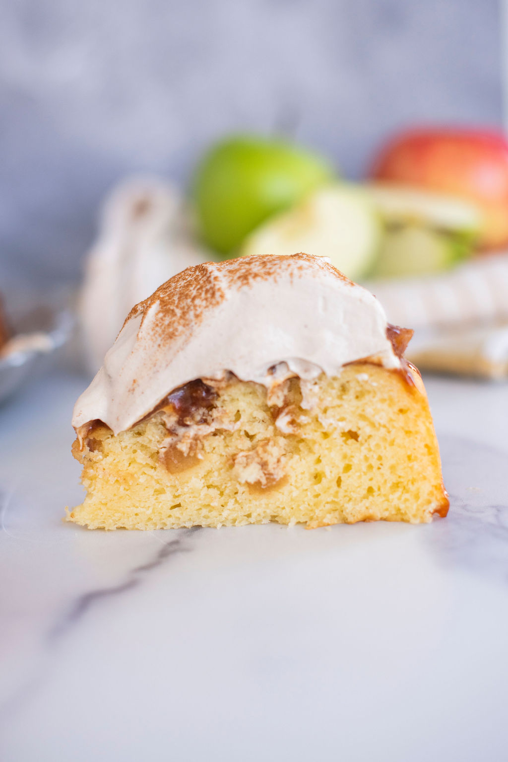 Slice fo apple ricotta cake with maple whipped cream.