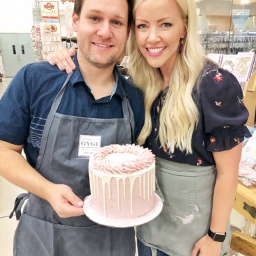 Courtney and her husband holding a cake made from a baking subscription box for a date night.