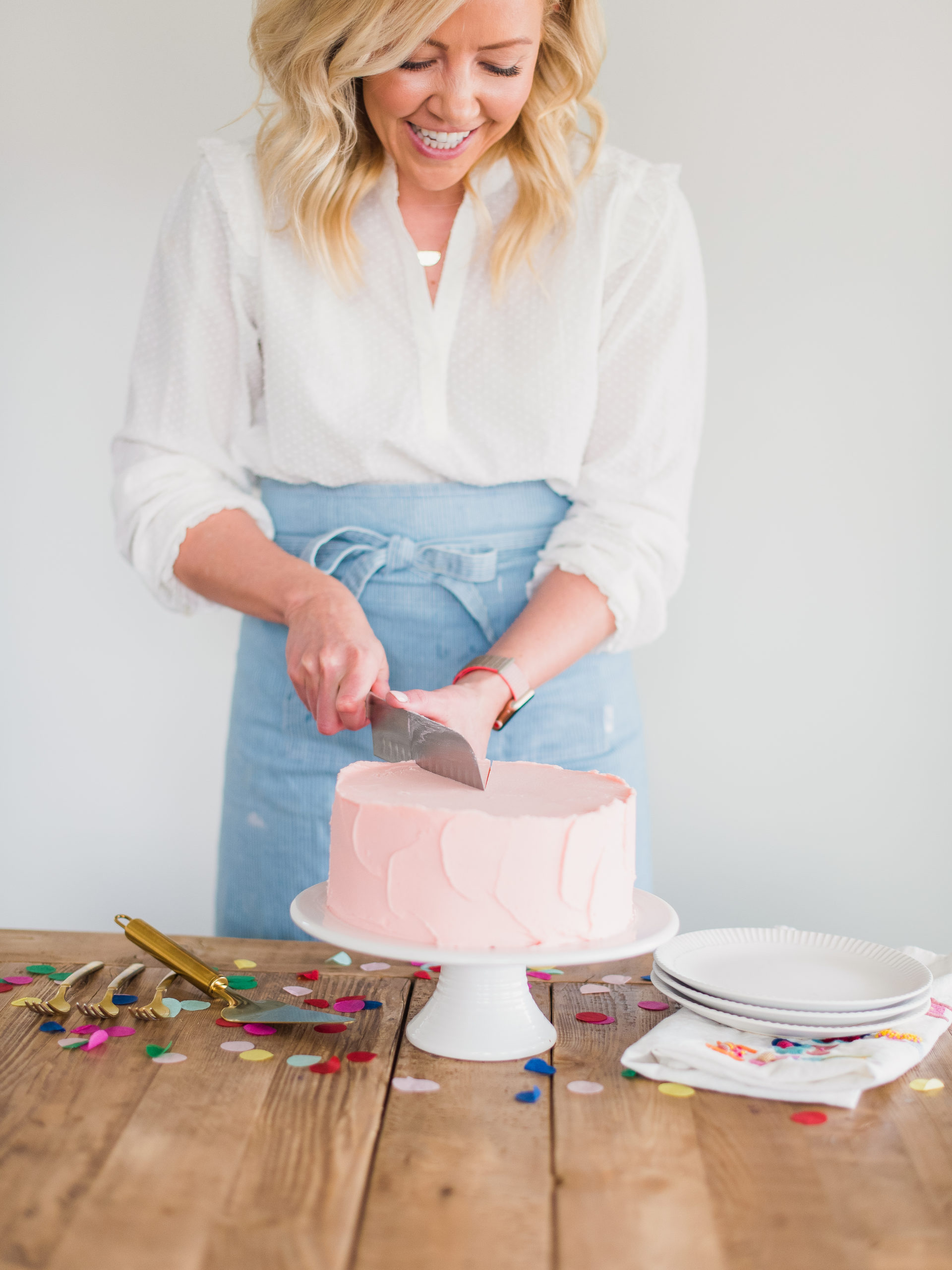 Woman cutting into a sugar free vanilla cake.