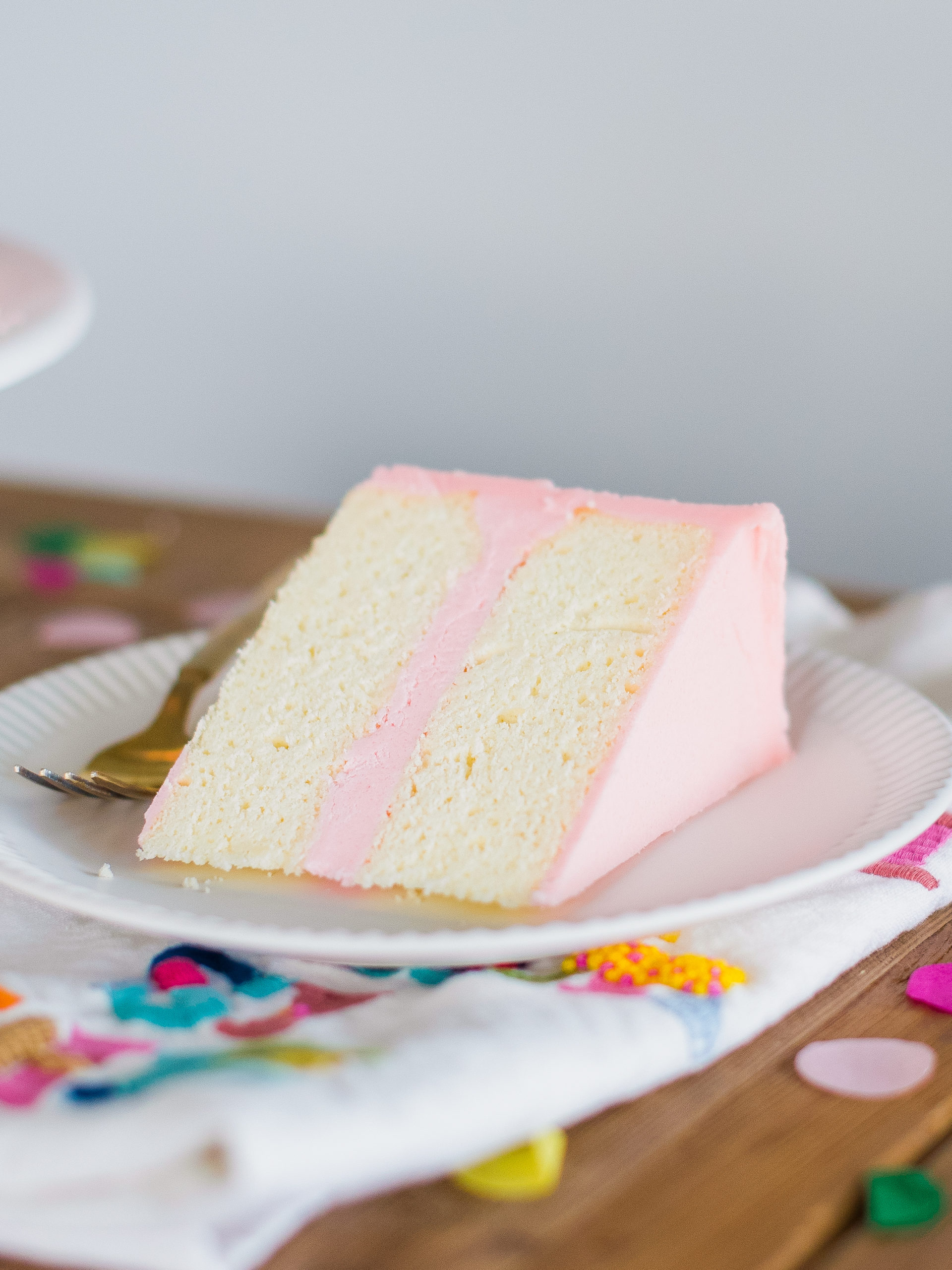 Slice of sugar free cake on a plate with confetti.