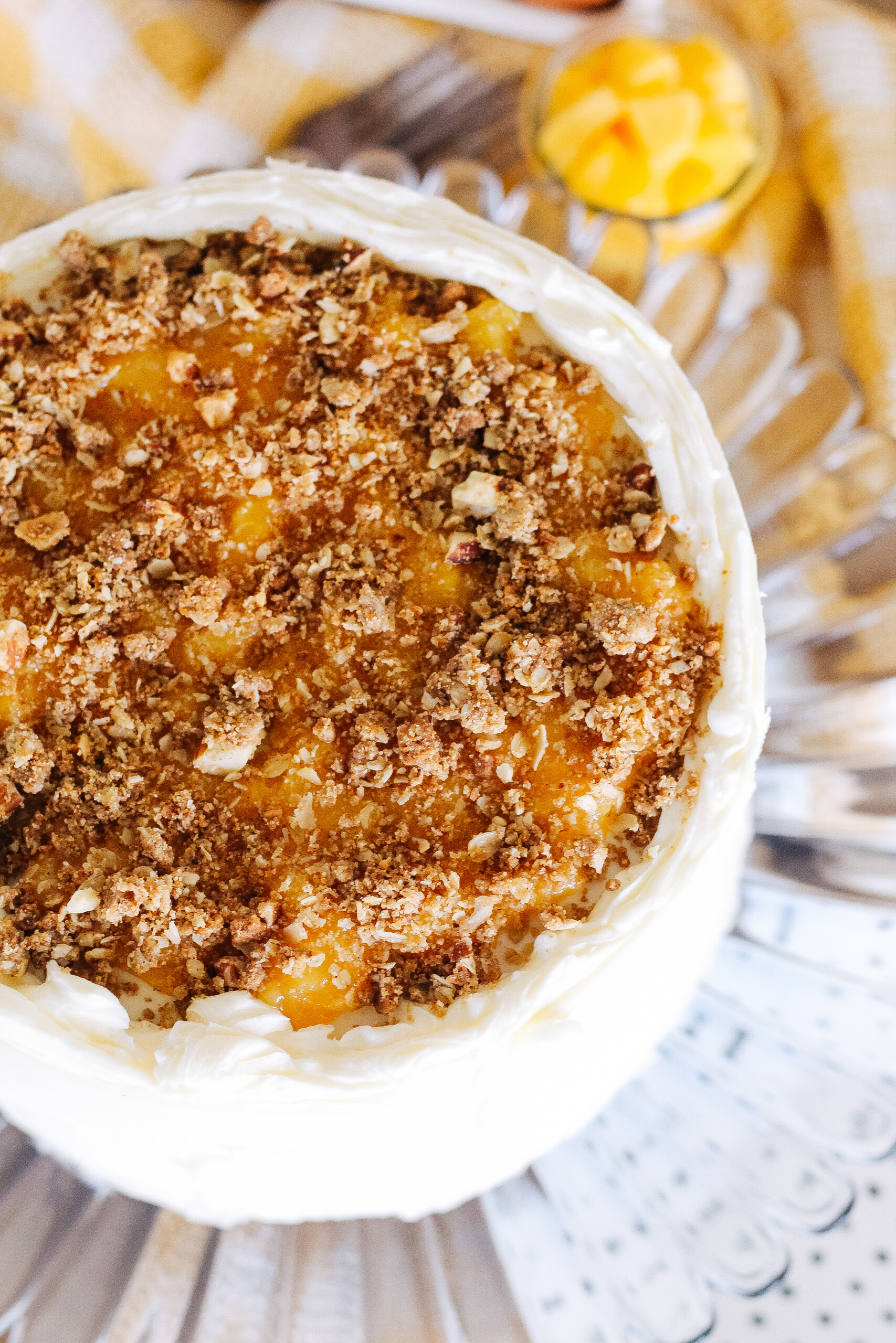 Top view of a cake with peach compote and oat crumble on top.