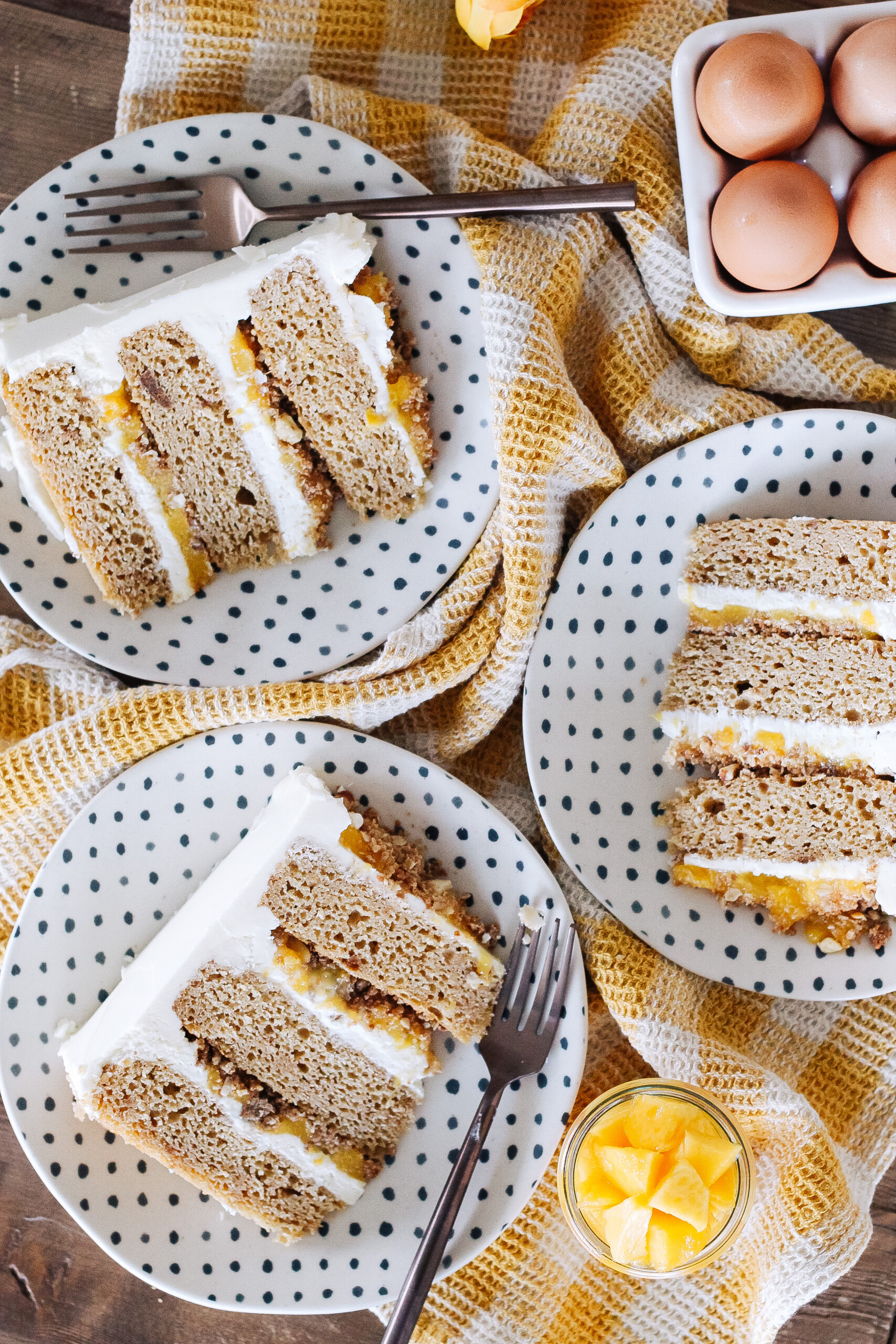 Three slices of cake on plates on a table.