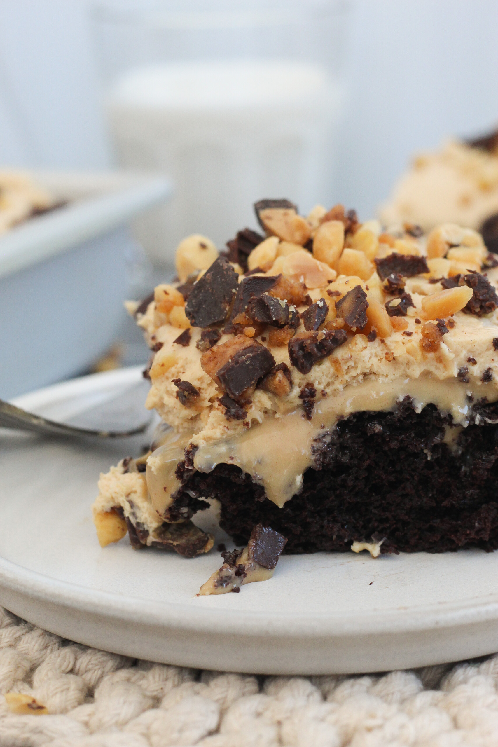 A slice of chocolate peanut butter poke cake on a plate.