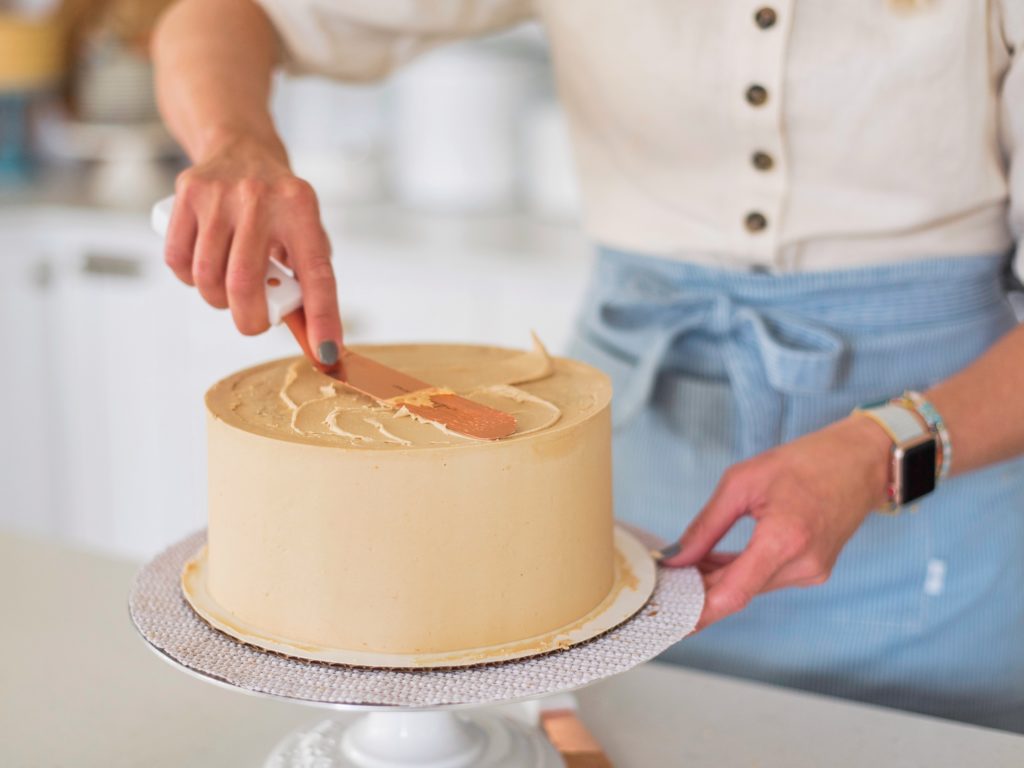 Oatmeal Biscoff Cake: oatmeal chocolate chip cake layers baked on a Biscoff crust, topped with Biscoff spread and Biscoff buttercream. #cakebycourtney #cakerecipe #oatmealcakerecipe #biscoff #cookiebutter #cookiebuttercakerecipe #biscoffbuttercream #cookiebutterbuttercream