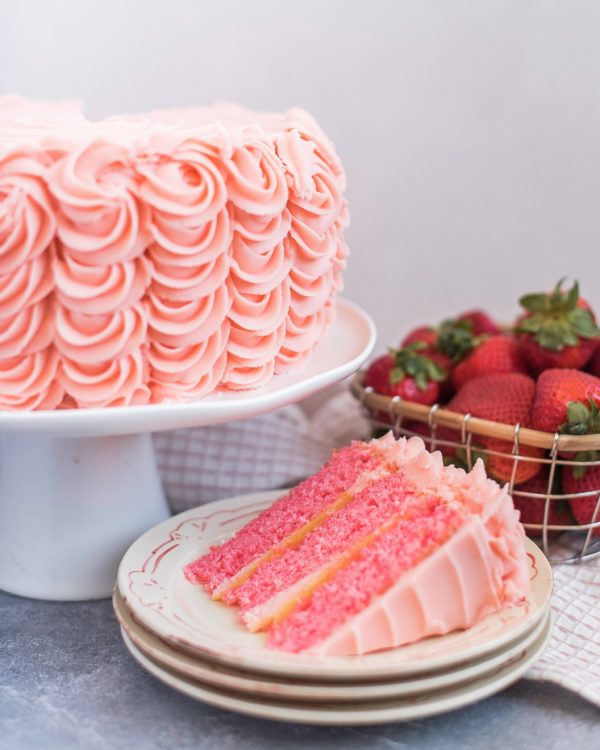 Strawberry Lemonade Cake - strawberry Jell-O cake layers with Lemond curd and strawberry buttercream - the perfect summer cake! #summercake #strawberrylemonadecake #strawberrycake #summercakerecipe #easysummercakerecipe #cakesforsummer #cakebycourtney
