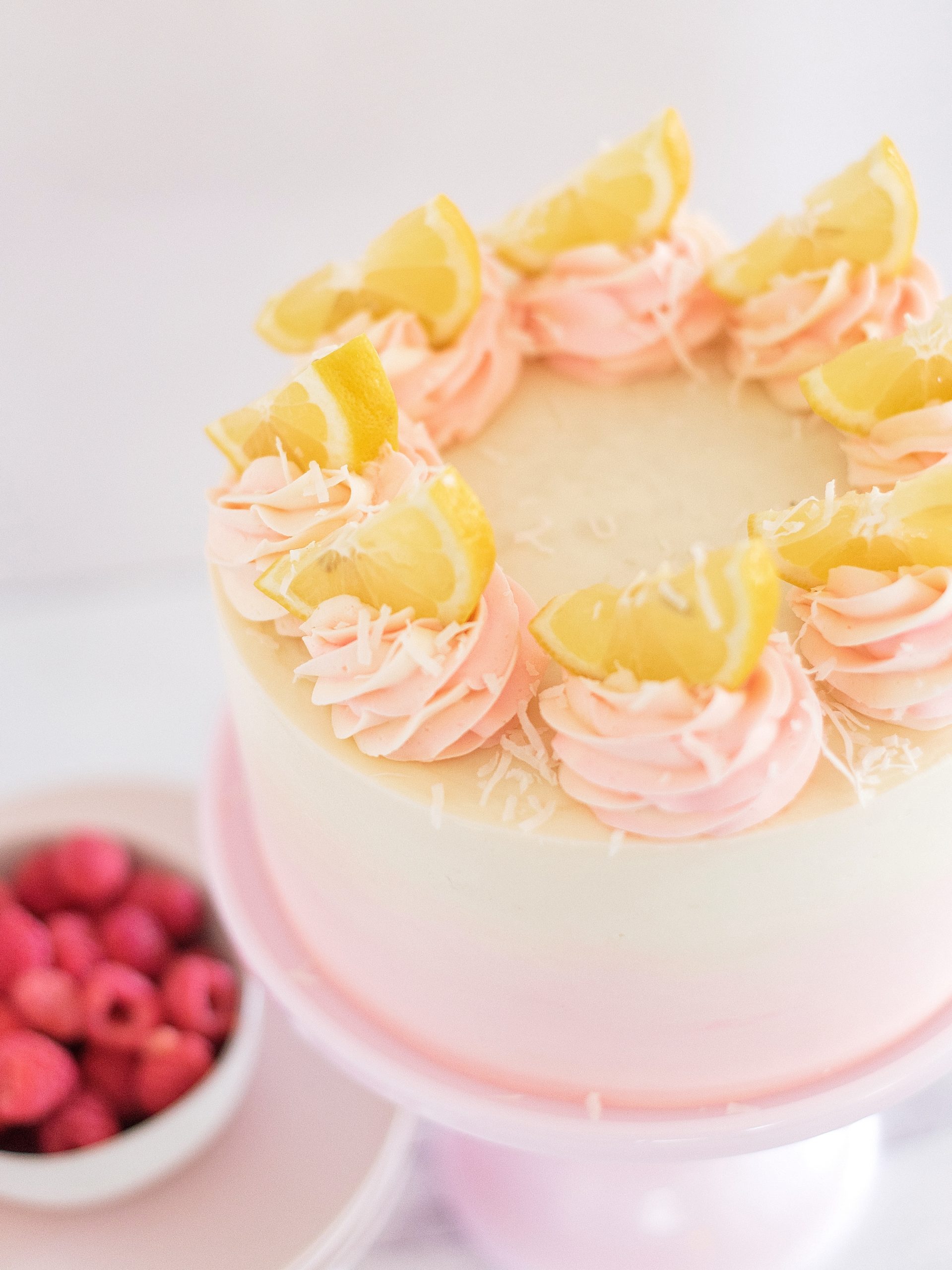 Coconut Lemon Raspberry Cake on a cake stand. 