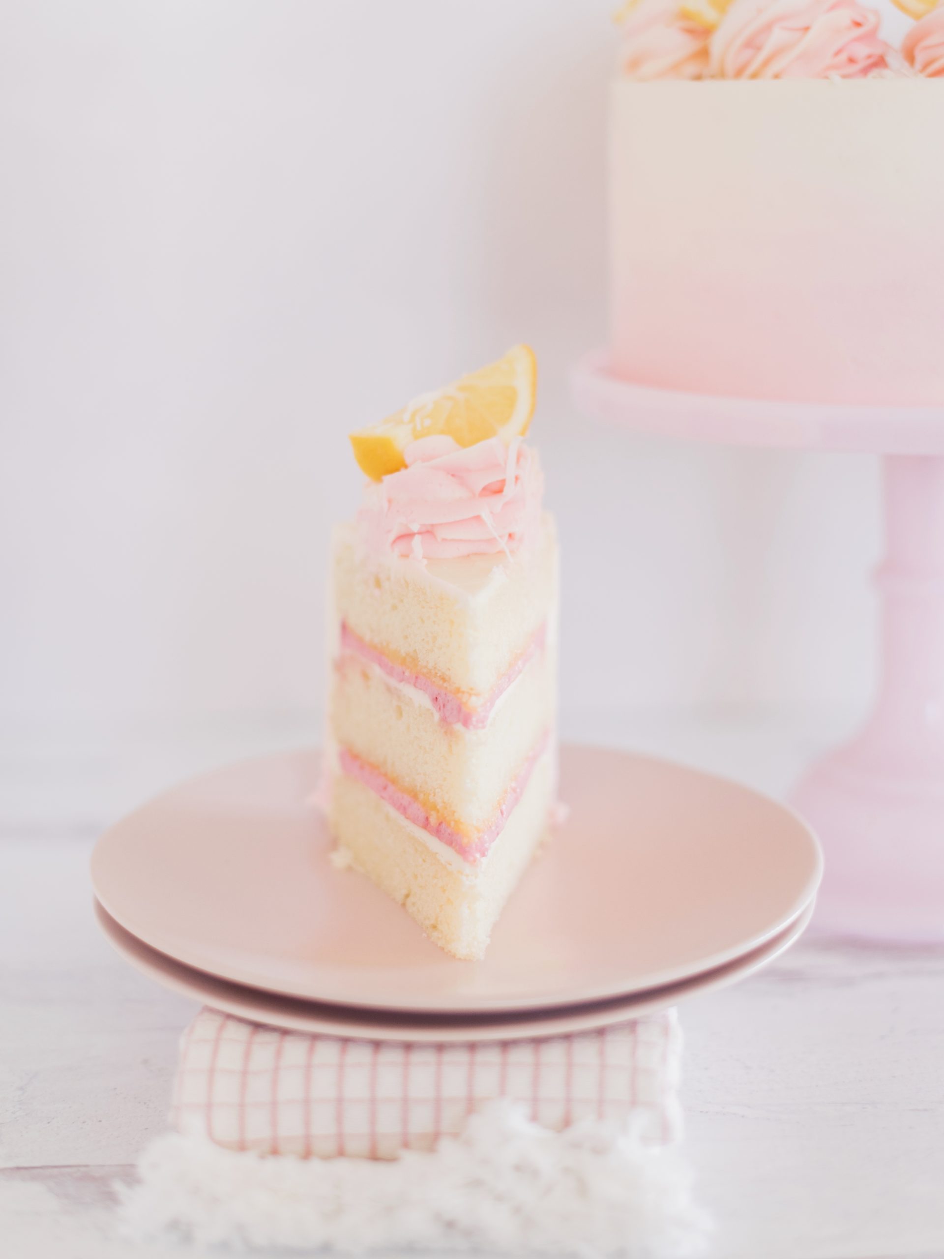 A slice of cake on a pink plate.