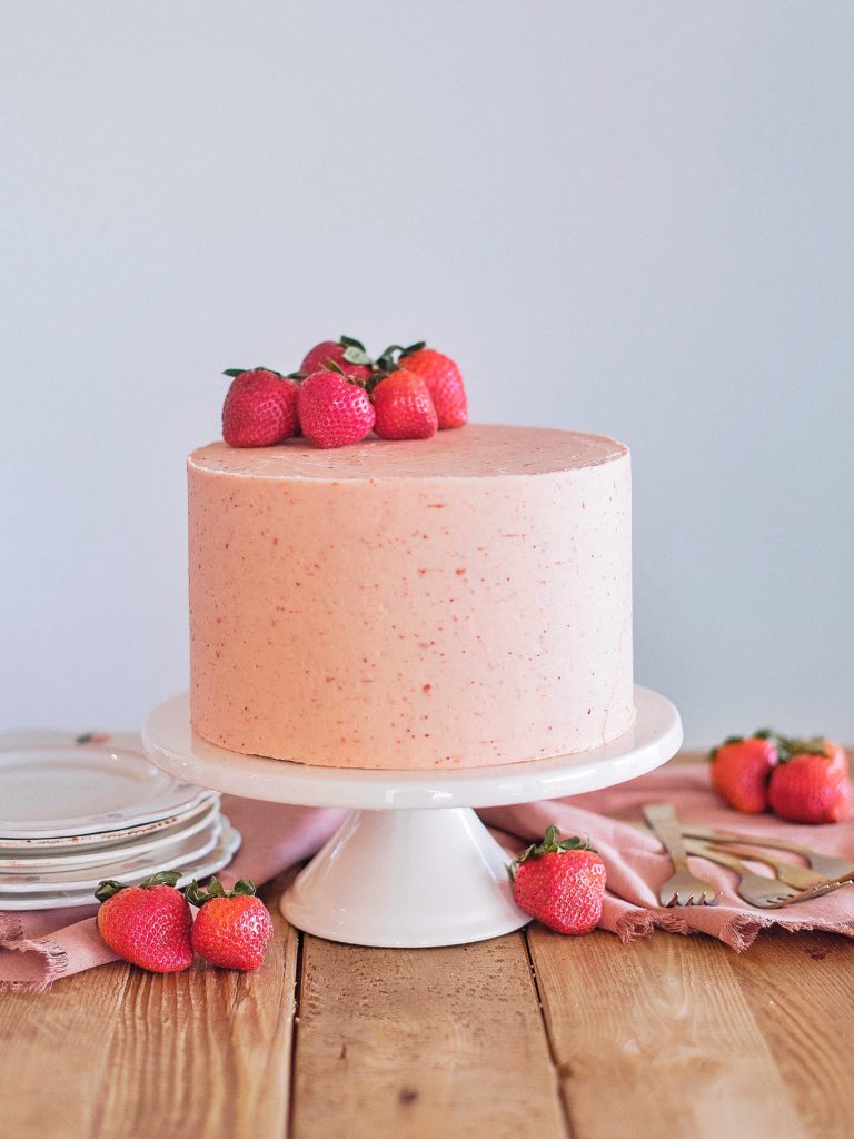 Strawberry Shortcake: Tender and fluffy layers of vanilla cake, filled with whipped cream and fresh strawberries, and covered in a strawberry buttercream. #cakebycourtney #cake #cakerecipe #strawberryshortcake #shortcake #strawberry #buttercream
