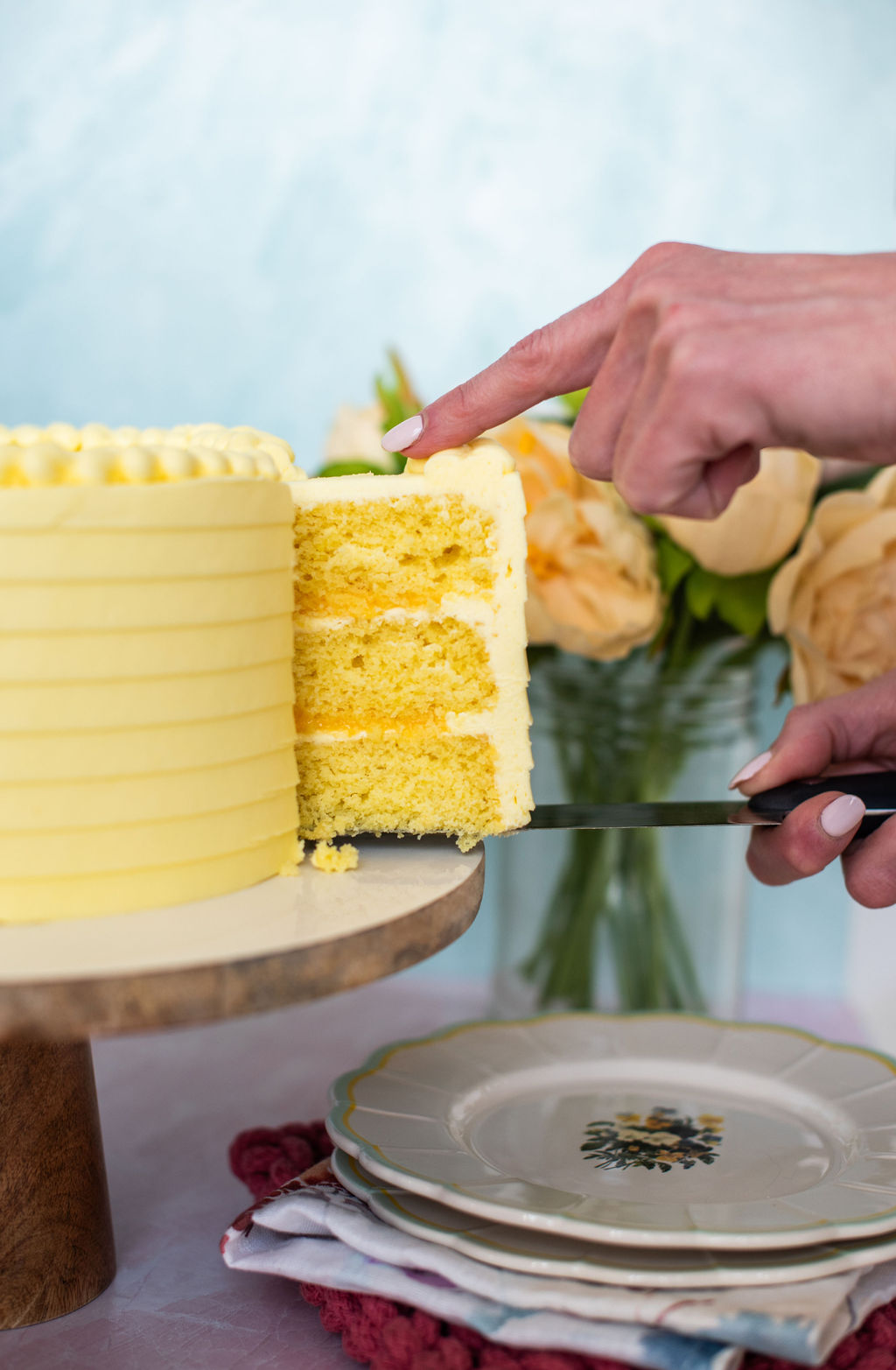 Taking a slice out of a whole lemon cake.
